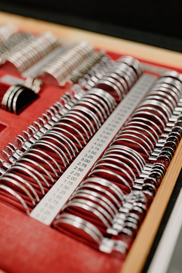 From above of opened case with various metal rim ophthalmic trial lens arranged in rows